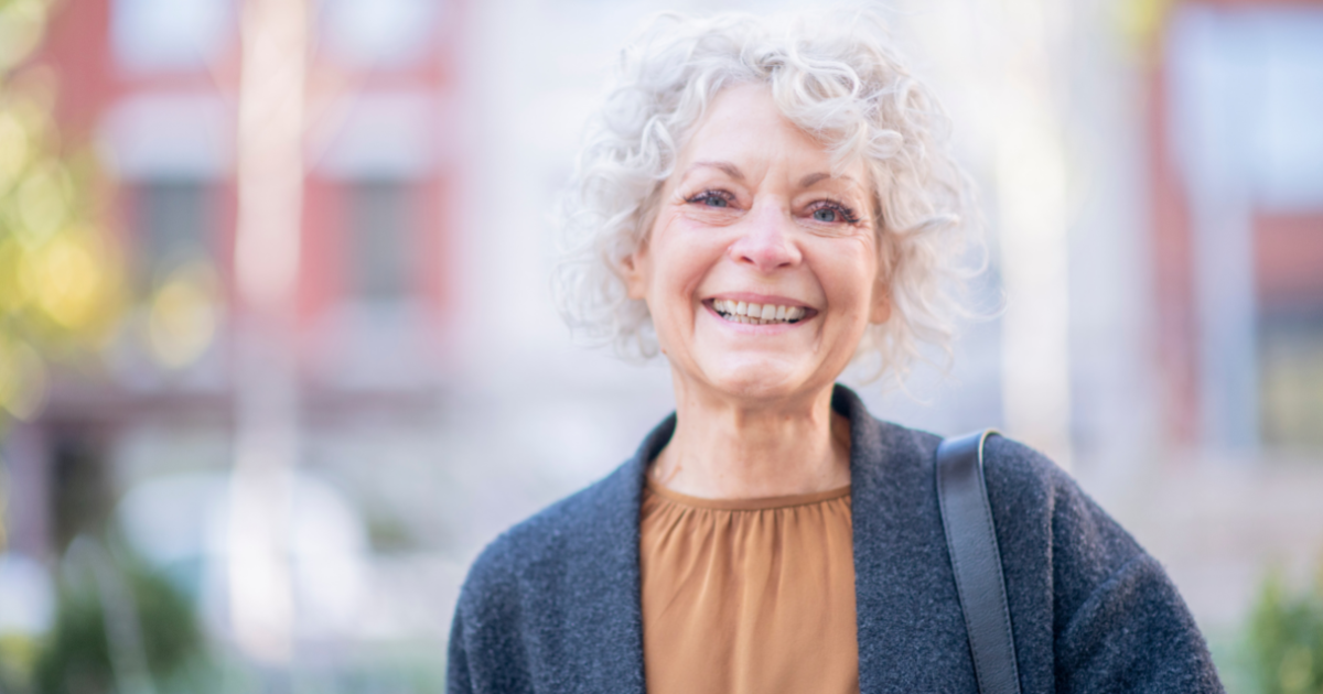 A woman is happy thanks to following good senior incontinence management practices.