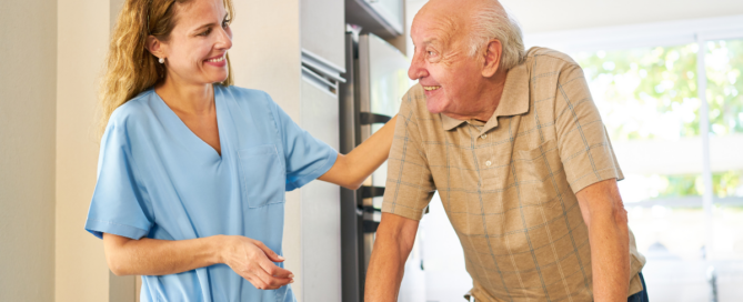 Caregiver smiling at senior man using a walker