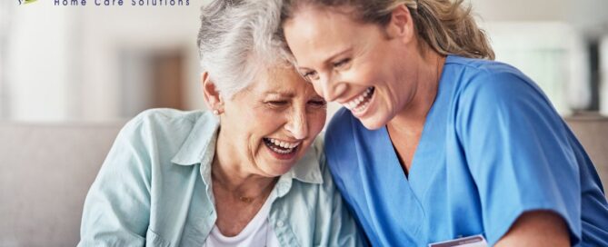 A woman who is providing companion care and her senior client laugh and enjoy their time together.