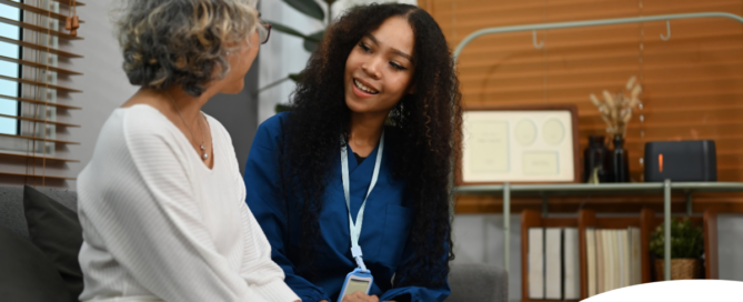 A caregiver patiently and kindly sits down and talks with a senior client, setting a good example for caregivers when it comes to communication.