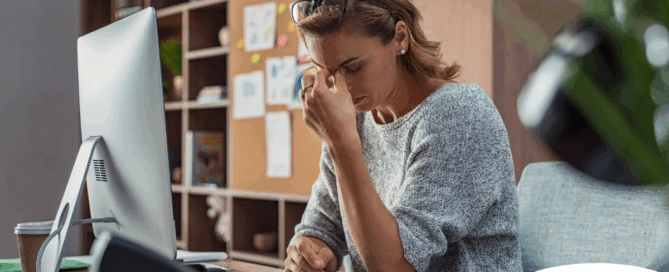A woman is exhausted at her job as a result of struggling with balancing caregiving and her career.