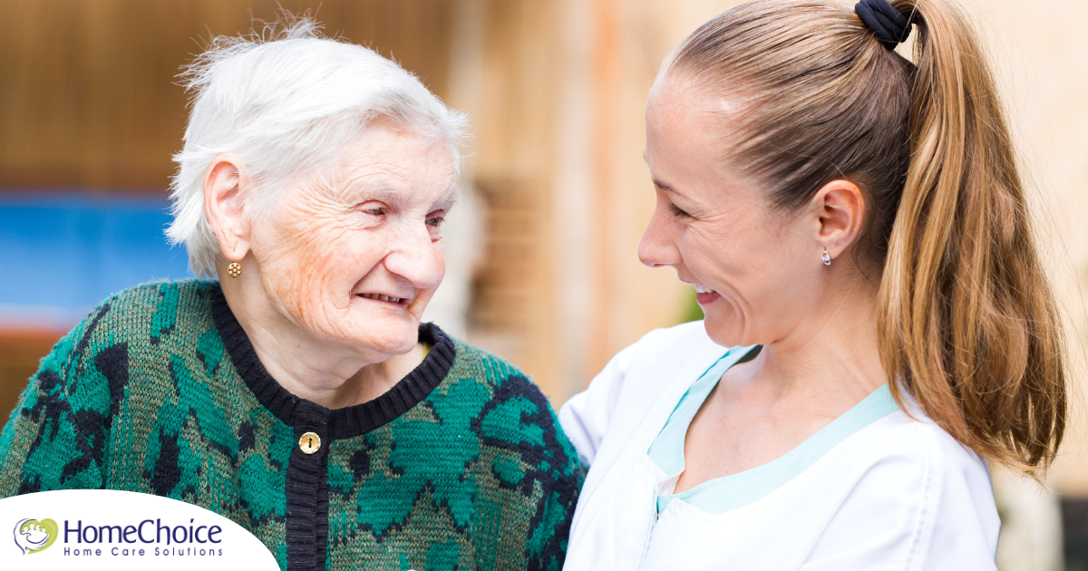 A professional caregiver compassionately hugs a senior client.