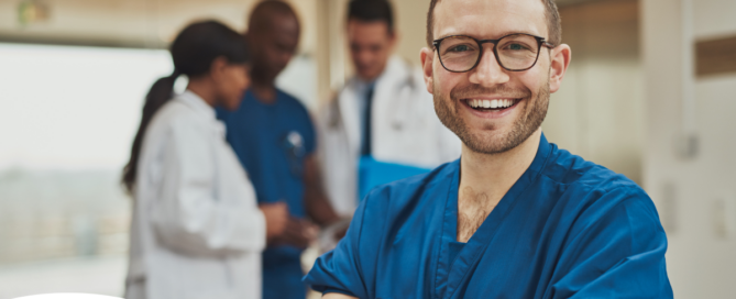 A young man in healthcare smiles, representing how a career as a professional caregiver can lead to a happy career as a healthcare professional.