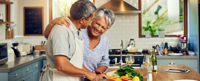 A senior couple enjoys cooking a healthy meal together, representing National Nutrition Month.