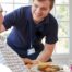 Professional caregiving involves helping clients with iADLs and ADLs as demonstrated by this caregiver helping a client by bringing a meal.