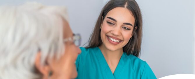 A caregiver smiles with an older client showing the results of successfully starting a new caregiving job.