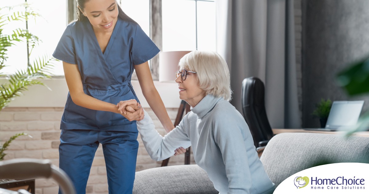 A caregiver demonstrates her caregiver skills by helping an older adult get up.