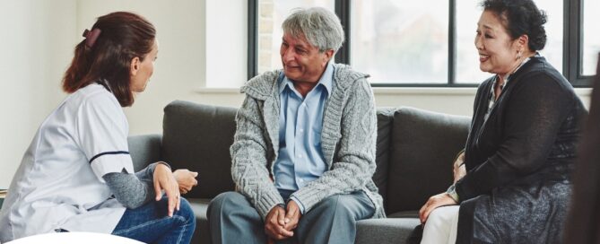A caregiver talks with an elderly couple representing the kind of communication that professional caregivers need to have to anticipate client needs.