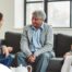 A caregiver talks with an elderly couple representing the kind of communication that professional caregivers need to have to anticipate client needs.