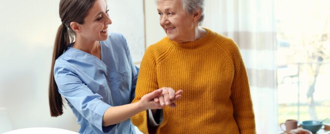 A caregiver helps a client get around, demonstrating one of the job duties of a caregiver.