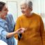 A caregiver helps a client get around, demonstrating one of the job duties of a caregiver.