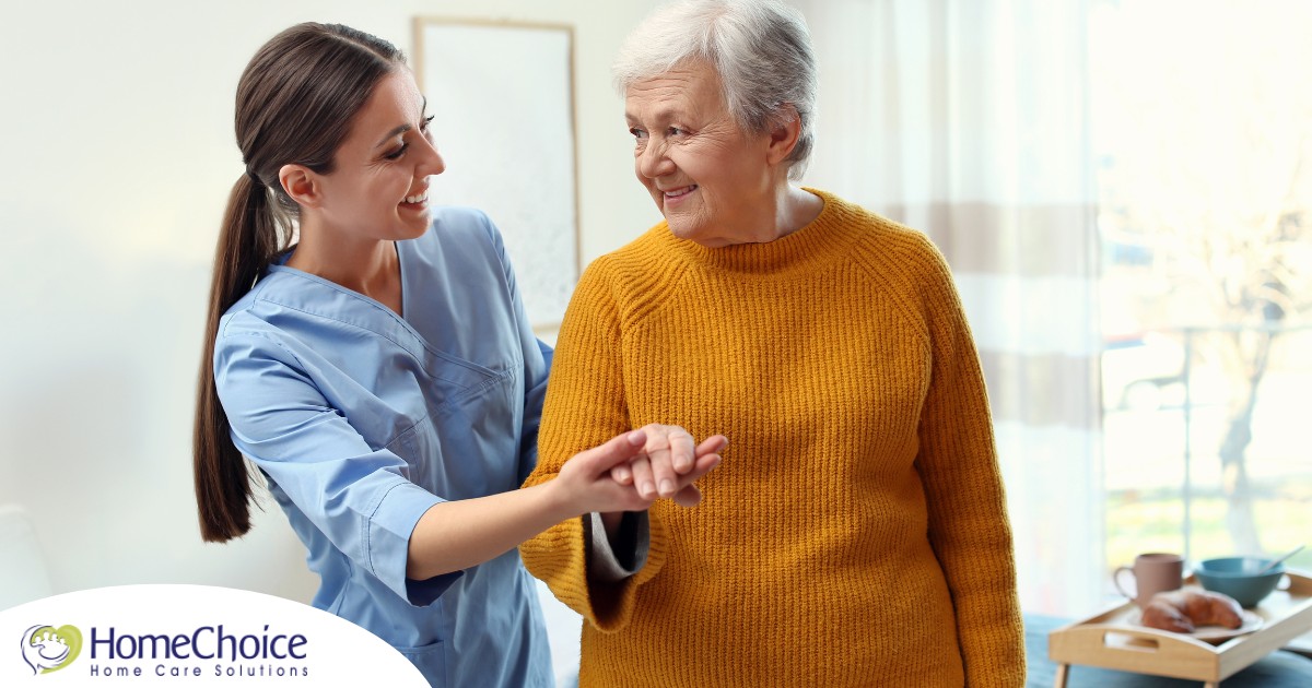 A caregiver helps a client get around, demonstrating one of the job duties of a caregiver.