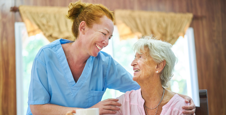 Home Care in Raleigh, NC Smiling caregiver supporting an elderly woman with home care in Raleigh, NC