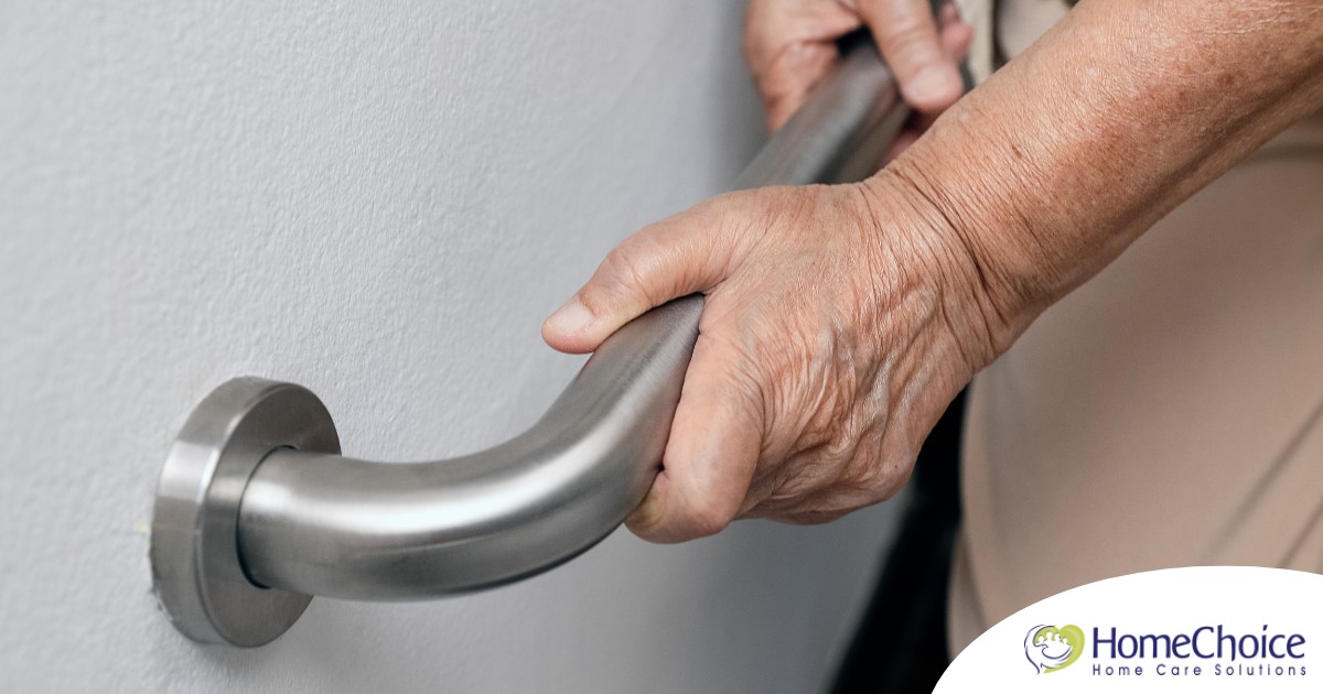 An older adult uses a grab bar representing one of the home modifications that is helpful for fall prevention for elderly adults.
