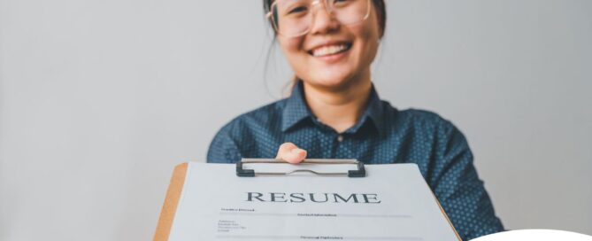 A woman happily hands in a resume, representing a successfully written caregiver resume.
