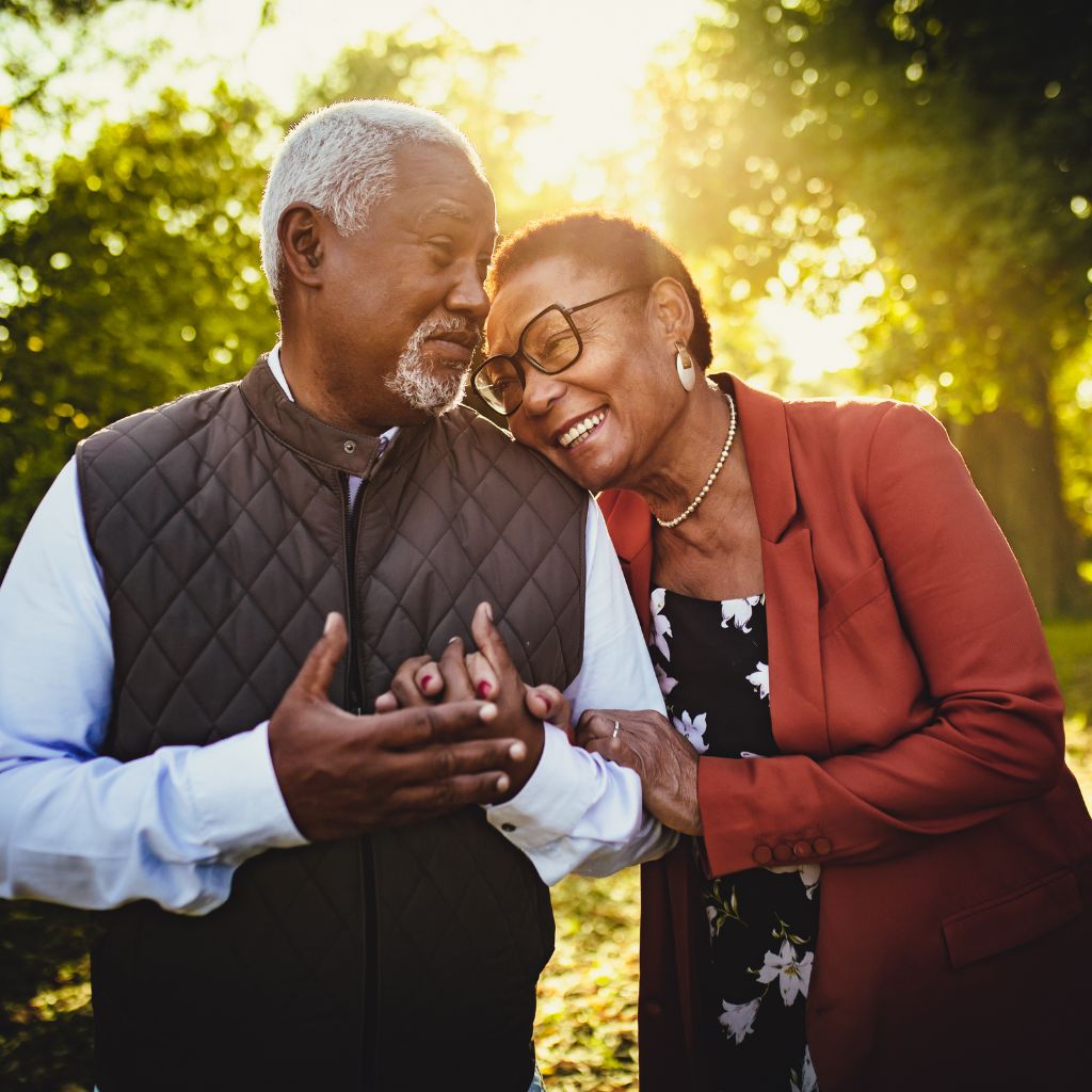 Smiling senior couple holding hands outdoors, representing compassionate Home Care in Fuquay-Varina, NC.