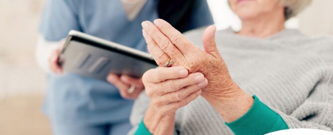 A caregiver provides in home care services to a senior with arthritis