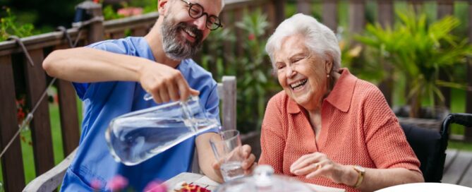 A caregiver applies summer Caregiving Tips including helping a senior stay hydrated.