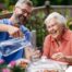 A caregiver applies summer Caregiving Tips including helping a senior stay hydrated.