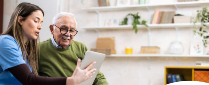 Home caregiver assisting senior man to use telehealth and senior care