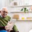 Home caregiver assisting senior man to use telehealth and senior care