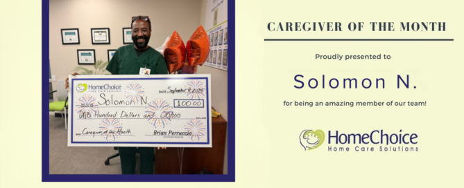 HomeChoice Home Care Solutions recognizes Solomon N. as the September 2026 Caregiver of the Month. Solomon smiles while holding a big check.