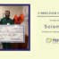 HomeChoice Home Care Solutions recognizes Solomon N. as the September 2026 Caregiver of the Month. Solomon smiles while holding a big check.