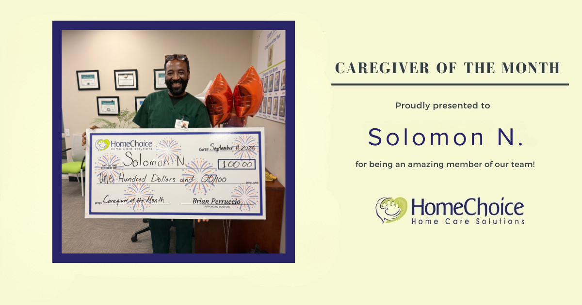 HomeChoice Home Care Solutions recognizes Solomon N. as the September 2026 Caregiver of the Month. Solomon smiles while holding a big check.