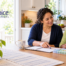HomeChoice caregiver reviewing a daily medication routine with an older woman beside a pill organizer and glass of water at home.