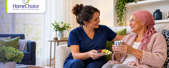 HomeChoice caregiver in navy scrubs sharing a healthy snack with a woman recovering from breast cancer at home with home care support.